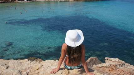 Fototapeta na wymiar Woman with a pamela hat sitting over a cliff