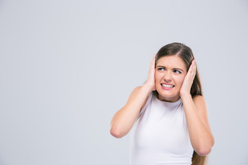 Female teenager covering her ears