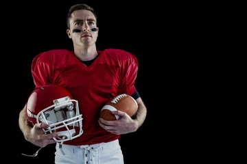 American football player holding helmet