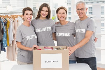 Smiling volunteers putting arms around each other