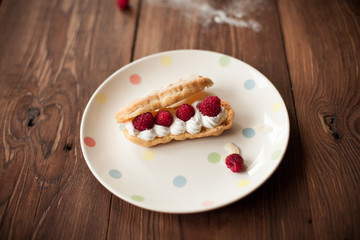 Fototapeta na wymiar Cream dessert with fresh raspberries on plate on wood table