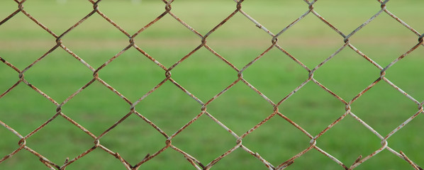 Fototapeta premium iron wire fence isolated on green background