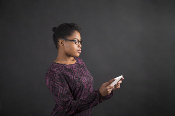 African woman with tablet on blackboard background