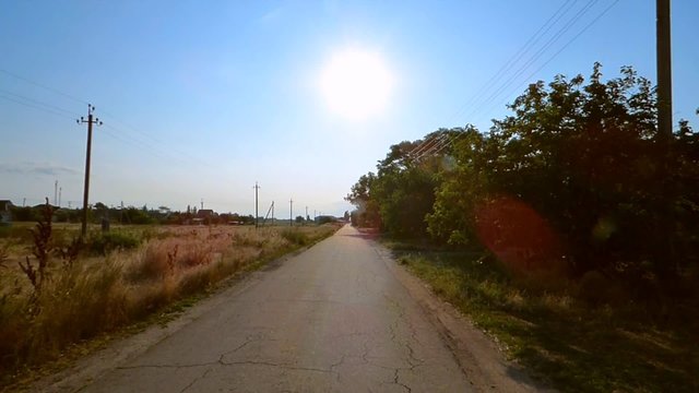 Traffic on the rural road towards the sun