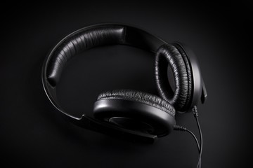 Fototapeta na wymiar Black Headphones on a black background