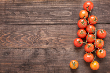 Fototapeta na wymiar Fresh cherry tomatoes on rustic wooden background