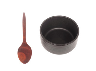 Black ceramic bowl with wooden spoon isolated