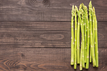 Bunch of fresh green asparagus on a rustic wooden table.