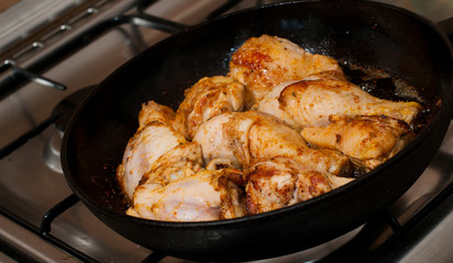 Frying pan with chicken legs inside