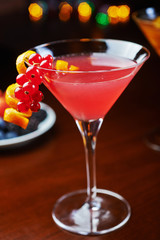 bright glass of delicious alcoholic martini cocktail or lemonade with ice and currant