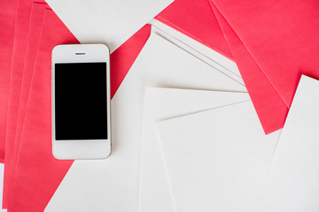 Smartphone with white and red paper sheets