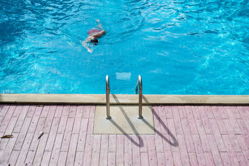 man is swimming in the swimming pool - 89352613