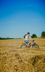 Fototapeta premium happy young man on a bicycle in the field
