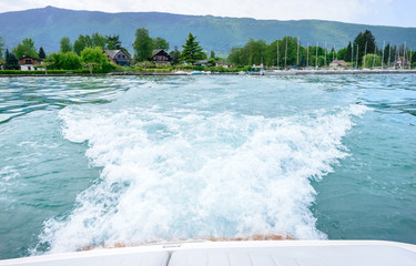 waves behind a motorboat on the lake