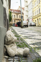 old teddy bear on the sidewalk in the city