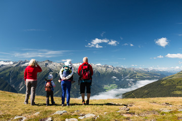 happy family with children and baby carrier enjoying beautiful valley in austrian alps
