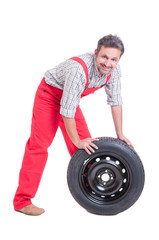 Smiling and friendly mechanic pushing a new tire