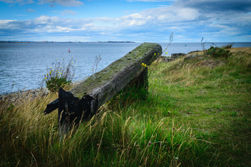 Very old wooden bench with the look at blue sea and the horizon