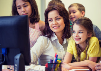 group of kids with teacher and computer at school
