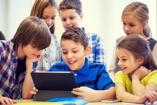 group of school kids with tablet pc in classroom