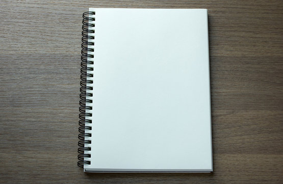 blank spiral notebook on dark wood background