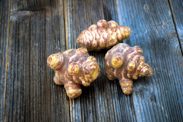 Fresh topinambur on wooden background