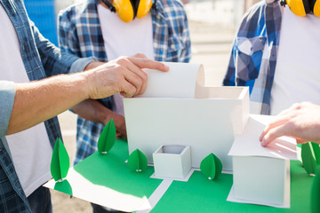 close up of builders with paper house model