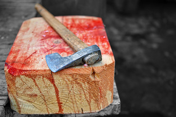 An axe on a wooden bloody hogger