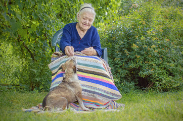 Happy old woman feeding her dog