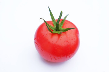 Tomate seule sur fond blanc avec feuilles et gouttes d'eau