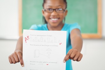 Proud pupil showing test result to camera