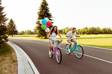 couple in love  riding a bicycle race with balloons - Powered by Adobe