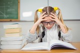 Concentrated pupil reading book at her desk