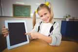 Smiling pupil pointing on tablet in a classroom