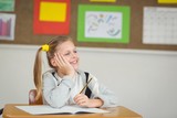 Smiling pupil daydreaming in a classroom
