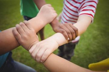 Diverse classmates holding arms 