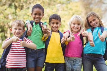 Smiling classmates doing thumbs up to camera