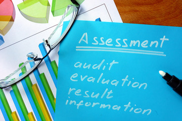 Blue paper with word assessment and glasses. 