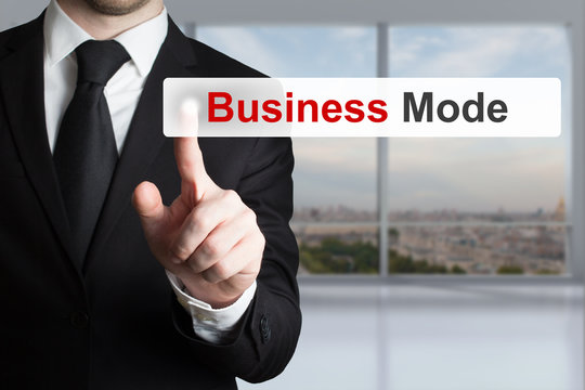 Gesch&auml;ftsmann in schwarzem Anzug dr&uuml;ckt Knopf Business Mode