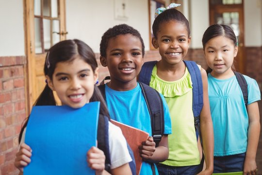 Cute Pupils Standing In A Row At Corridor