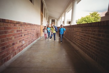 Happy pupils walking at corridor