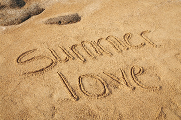 The words Summer Love written in the sand on the beach