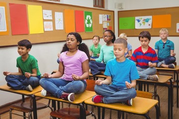 Pupils meditating on classroom desks