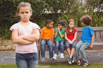Upset child standing away from group