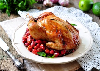 chicken baked with dogwood, garlic and rosemary on a wooden table
