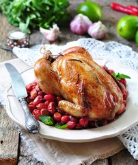 chicken baked with dogwood, garlic and rosemary on a wooden table