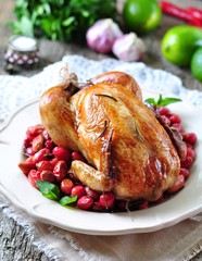 chicken baked with dogwood, garlic and rosemary on a wooden table