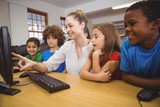 Teacher showing students how to use a computer