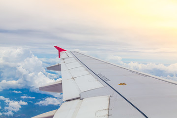 Obraz premium Wing of an airplane flying above the clouds