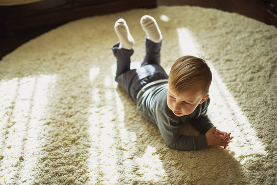 little boy lying on the carpet